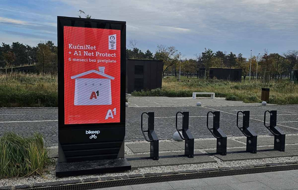 A Bikeep station with an A1 campaign on its screen, in front of the BC Ušće towers