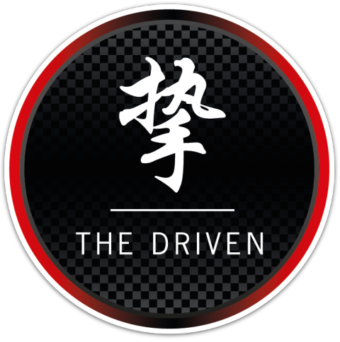 The Driven icon, a seal in red and carbon
