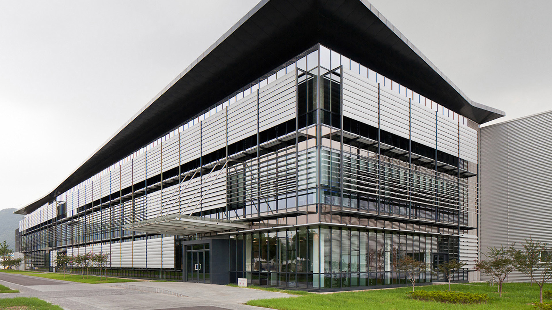 VirtuArch: a modern building with a steel and glass facade under a wide flat roof